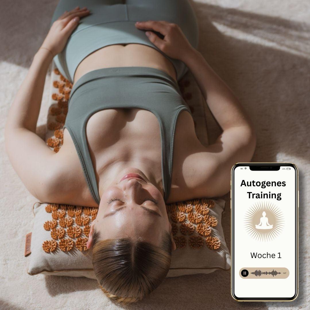 Woman practicing autogenes training lying on XL acupressure mat with smartphone displaying audio session